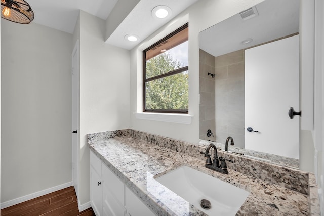 bathroom featuring a tile shower and vanity