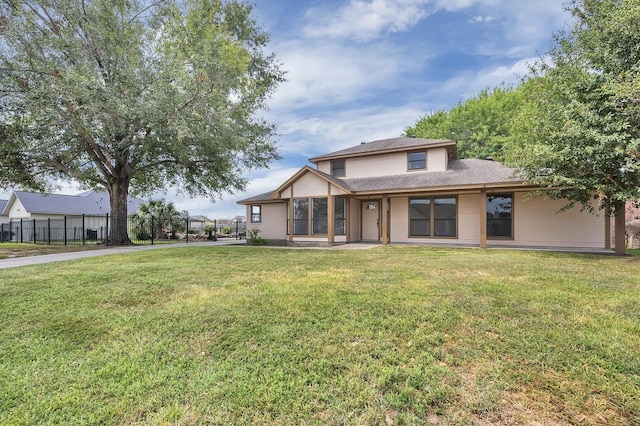 view of front facade with a front lawn and fence