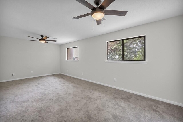 carpeted spare room with baseboards and ceiling fan