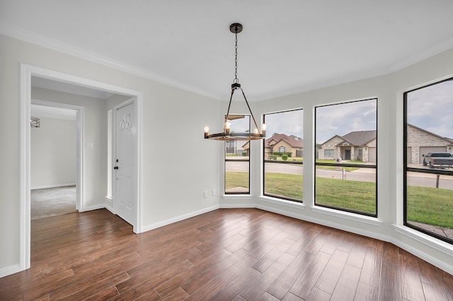 unfurnished dining area with crown molding, wood-type flooring, and a notable chandelier