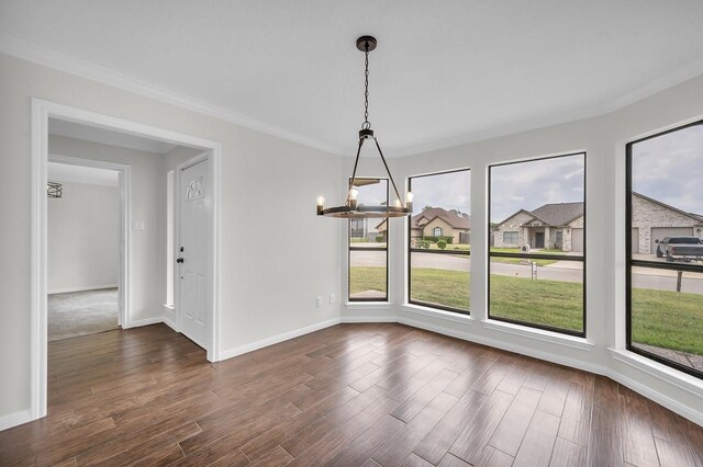 unfurnished dining area featuring baseboards, a notable chandelier, dark wood finished floors, and ornamental molding