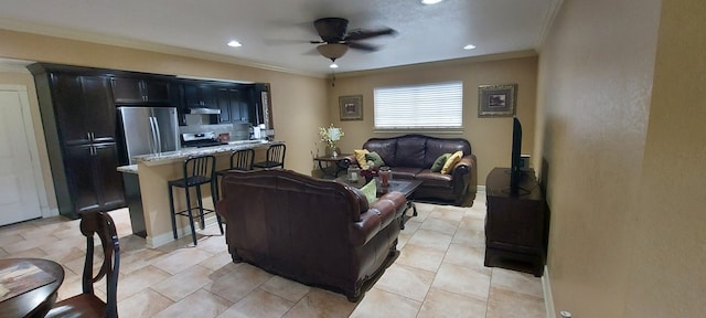 tiled living room with ornamental molding and ceiling fan