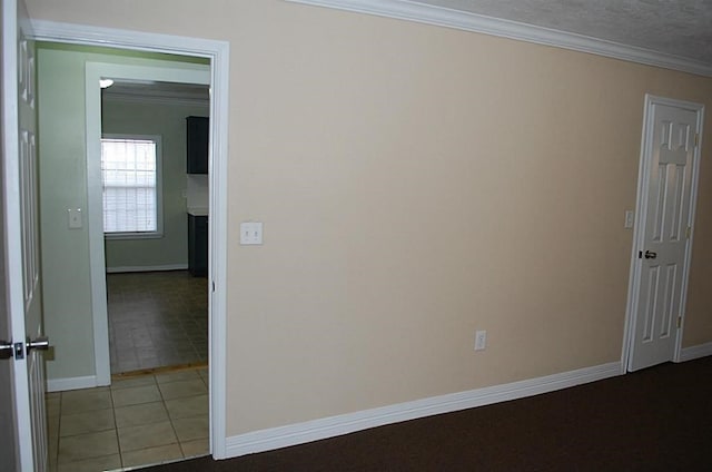 tiled spare room featuring ornamental molding