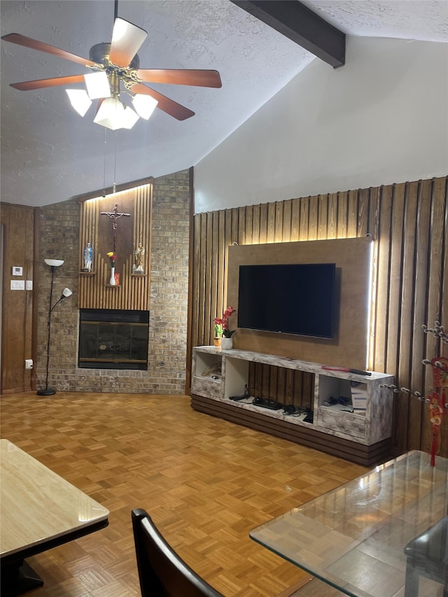 living room featuring ceiling fan, wooden walls, parquet flooring, beamed ceiling, and a textured ceiling