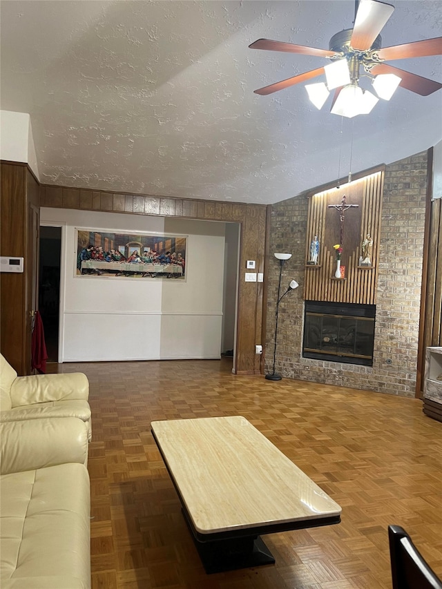 living room featuring brick wall, a textured ceiling, ceiling fan, and parquet flooring