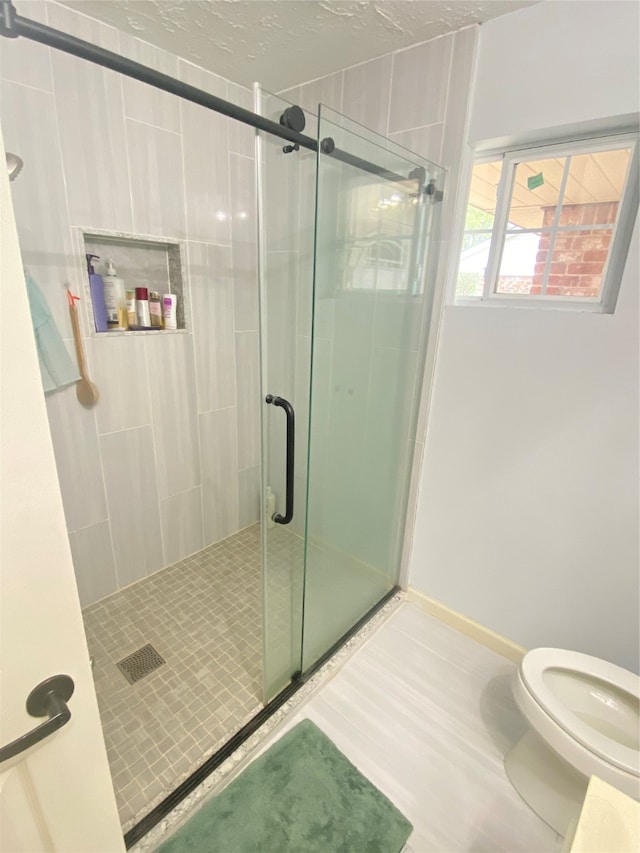 bathroom featuring walk in shower and toilet