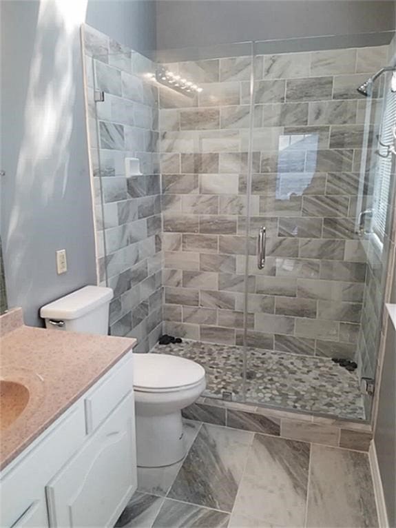 bathroom with vanity, a shower with shower door, toilet, and tile patterned flooring