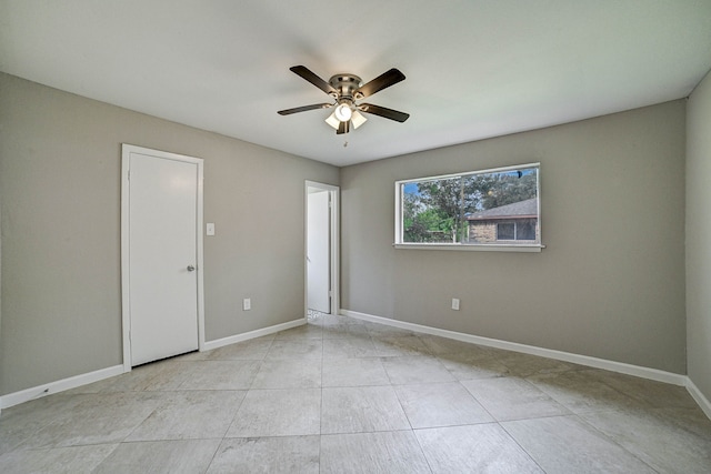 empty room with light tile patterned flooring and ceiling fan