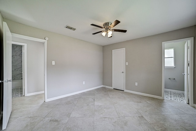 unfurnished bedroom with ensuite bathroom, light tile patterned floors, and ceiling fan