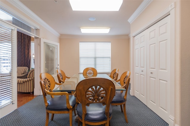 carpeted dining room featuring crown molding