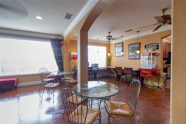 dining room with crown molding, a textured ceiling, and ceiling fan