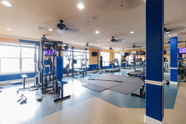 gym with a textured ceiling, ornamental molding, and ceiling fan