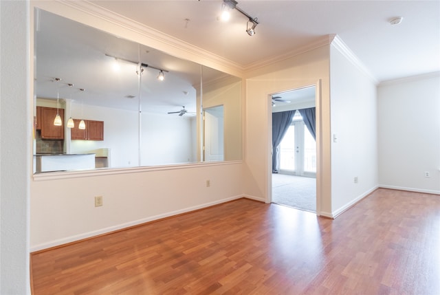 unfurnished living room featuring hardwood / wood-style floors, french doors, rail lighting, ceiling fan, and ornamental molding