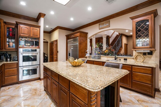 kitchen with a center island, crown molding, stainless steel appliances, and backsplash