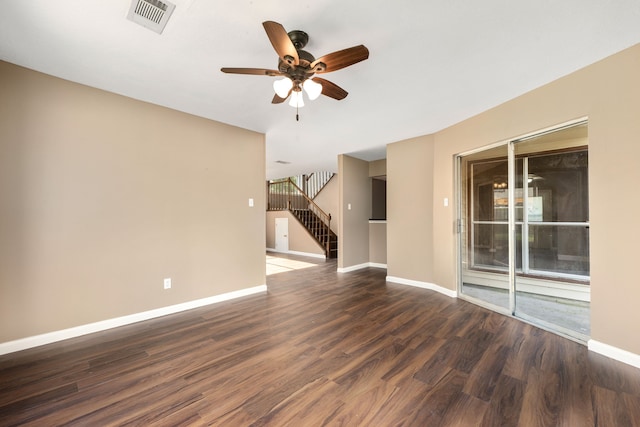 unfurnished room featuring baseboards, stairs, visible vents, and dark wood-style flooring