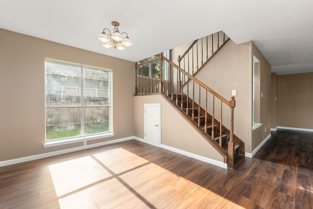 interior space with plenty of natural light, baseboards, a chandelier, and wood finished floors