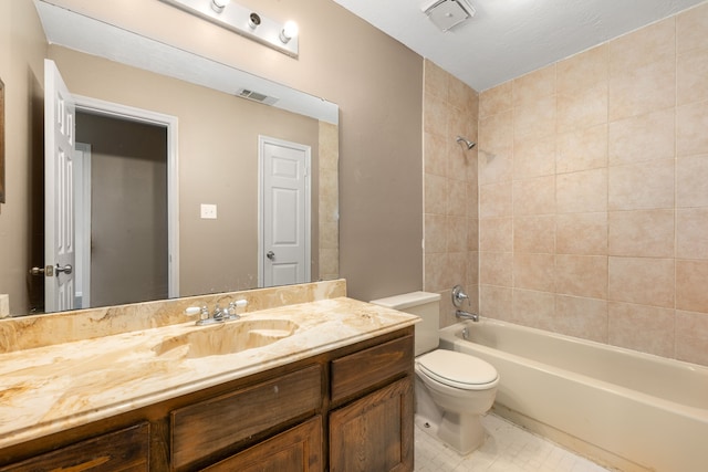 full bathroom featuring vanity, tile patterned floors, tiled shower / bath, and toilet