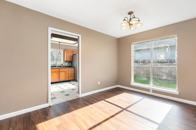 spare room with tile patterned flooring, a notable chandelier, and sink