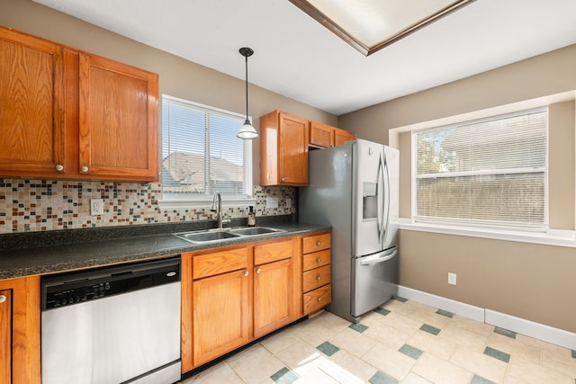 kitchen with stainless steel appliances, hanging light fixtures, sink, light tile patterned floors, and backsplash