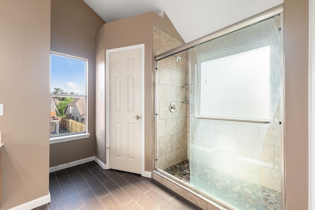 full bathroom with a shower stall and baseboards