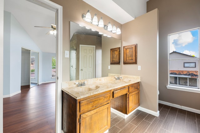 bathroom featuring double vanity, baseboards, and a sink