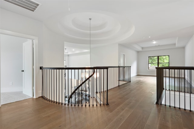 hall featuring hardwood / wood-style flooring and a raised ceiling