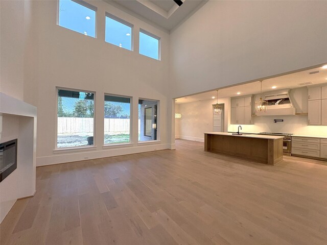 unfurnished living room with a towering ceiling and hardwood / wood-style floors