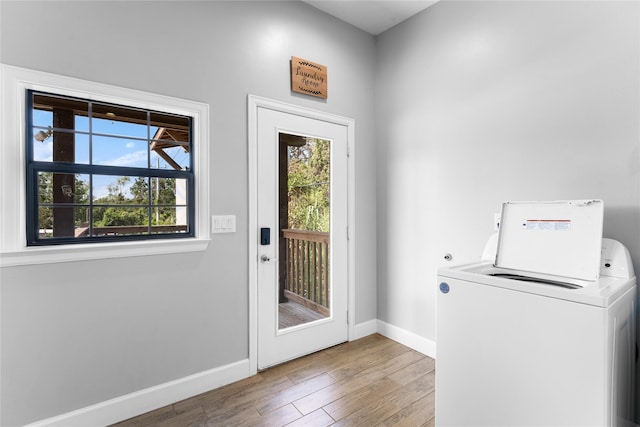 doorway to outside with washer / dryer and light hardwood / wood-style flooring