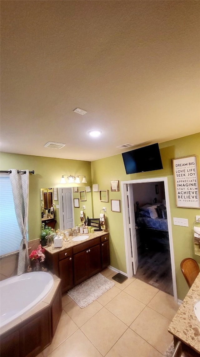 bathroom with tile patterned floors, vanity, and a tub