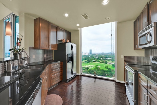 kitchen with dark wood-type flooring, stainless steel appliances, tasteful backsplash, and sink