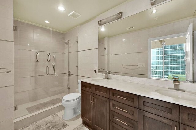 bathroom with vanity, an enclosed shower, toilet, and tile walls