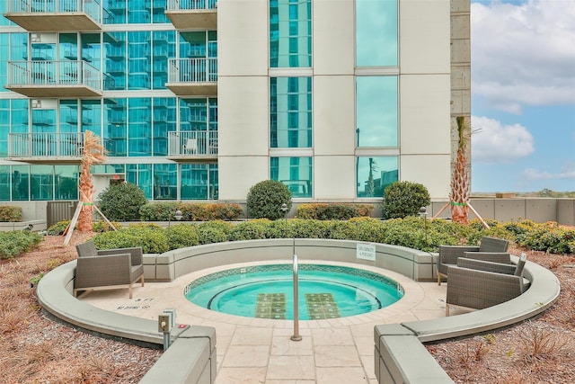 view of swimming pool featuring a hot tub