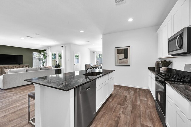 kitchen featuring stainless steel appliances, sink, a center island with sink, and white cabinets