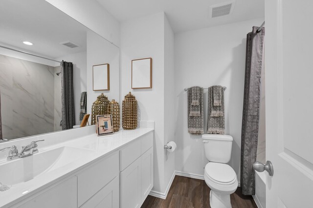 bathroom with vanity, hardwood / wood-style floors, and toilet