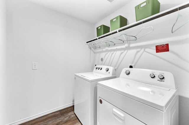 laundry room with dark hardwood / wood-style flooring and washing machine and dryer