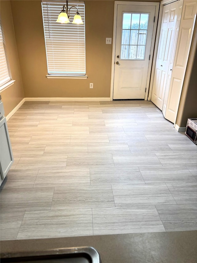 unfurnished dining area with wood finish floors and baseboards