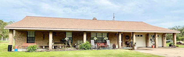 view of front of home featuring a garage, covered porch, and a front lawn