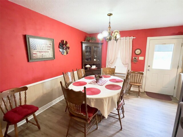 dining room featuring wood-type flooring and a chandelier