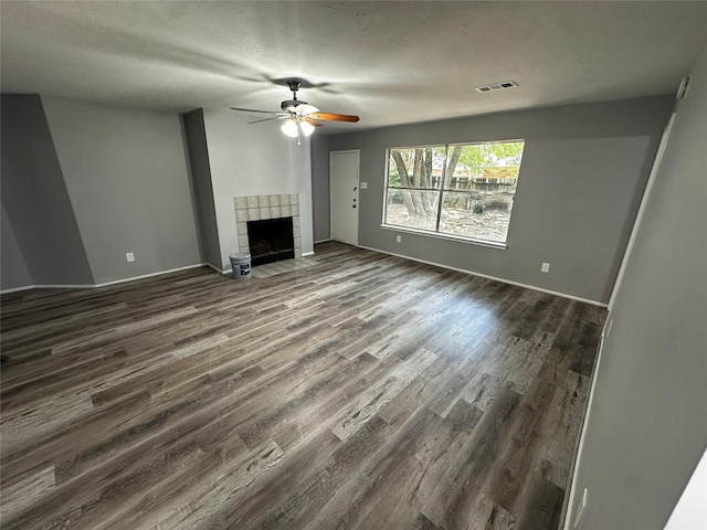 unfurnished living room featuring a tile fireplace, ceiling fan, and hardwood / wood-style flooring