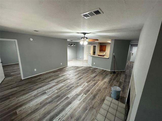 unfurnished living room featuring tile patterned flooring, a textured ceiling, and ceiling fan