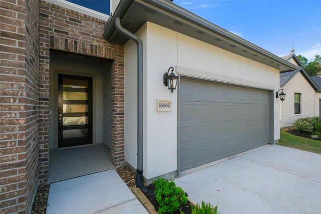 16006 Ruby Laurel Ct, Conroe, TX 77302 - entrance to property featuring an attached garage, brick siding, and driveway