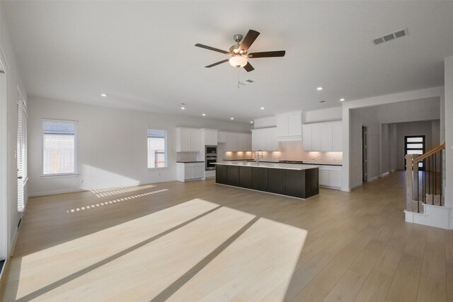 16006 Ruby Laurel Ct, Conroe, TX 77302 - kitchen with decorative backsplash, recessed lighting, open floor plan, a sink, and a ceiling fan
