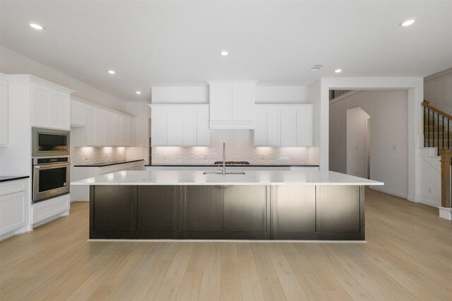 16006 Ruby Laurel Ct, Conroe, TX 77302 - kitchen featuring oven, built in microwave, a large island with sink, backsplash, and recessed lighting