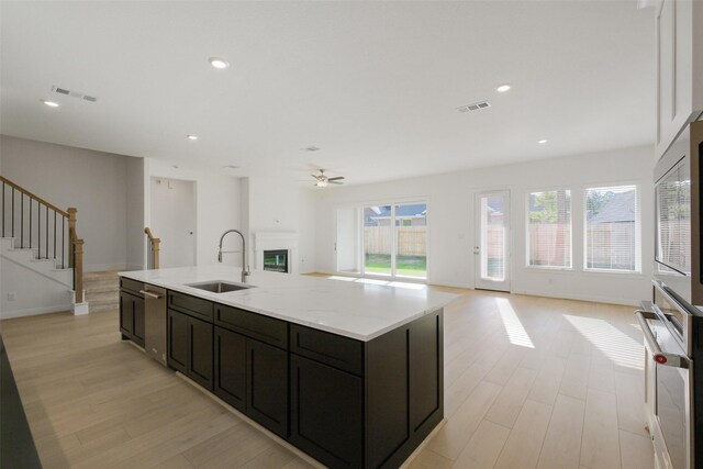 16006 Ruby Laurel Ct, Conroe, TX 77302 - kitchen featuring a sink, stainless steel appliances, light wood-style flooring, open floor plan, and a ceiling fan