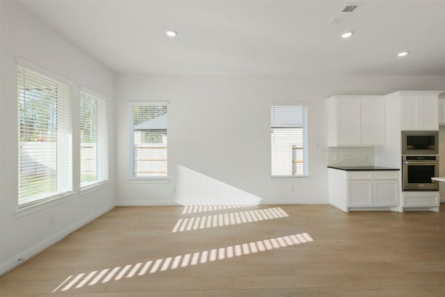 16006 Ruby Laurel Ct, Conroe, TX 77302 - unfurnished living room featuring light wood-type flooring, baseboards, and recessed lighting