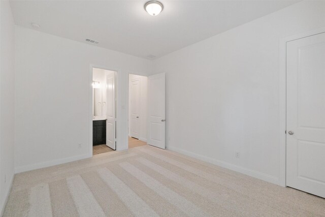 16006 Ruby Laurel Ct, Conroe, TX 77302 - unfurnished bedroom with light carpet, baseboards, and ensuite bath