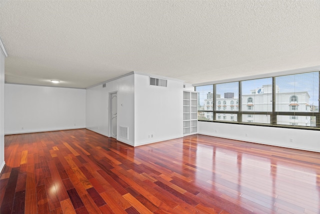 empty room with hardwood / wood-style floors and a textured ceiling