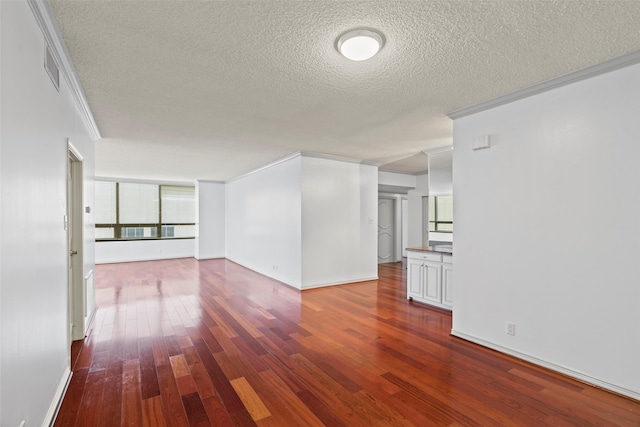 unfurnished living room featuring hardwood / wood-style floors, a textured ceiling, and ornamental molding