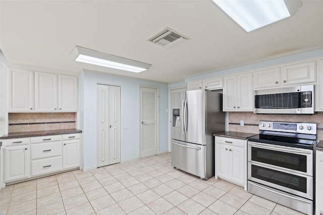 kitchen featuring white cabinets, appliances with stainless steel finishes, tasteful backsplash, and light tile patterned floors