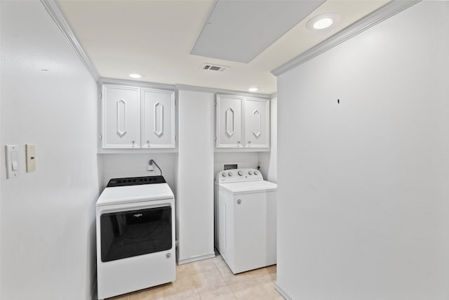 clothes washing area with washer and clothes dryer, cabinets, and ornamental molding